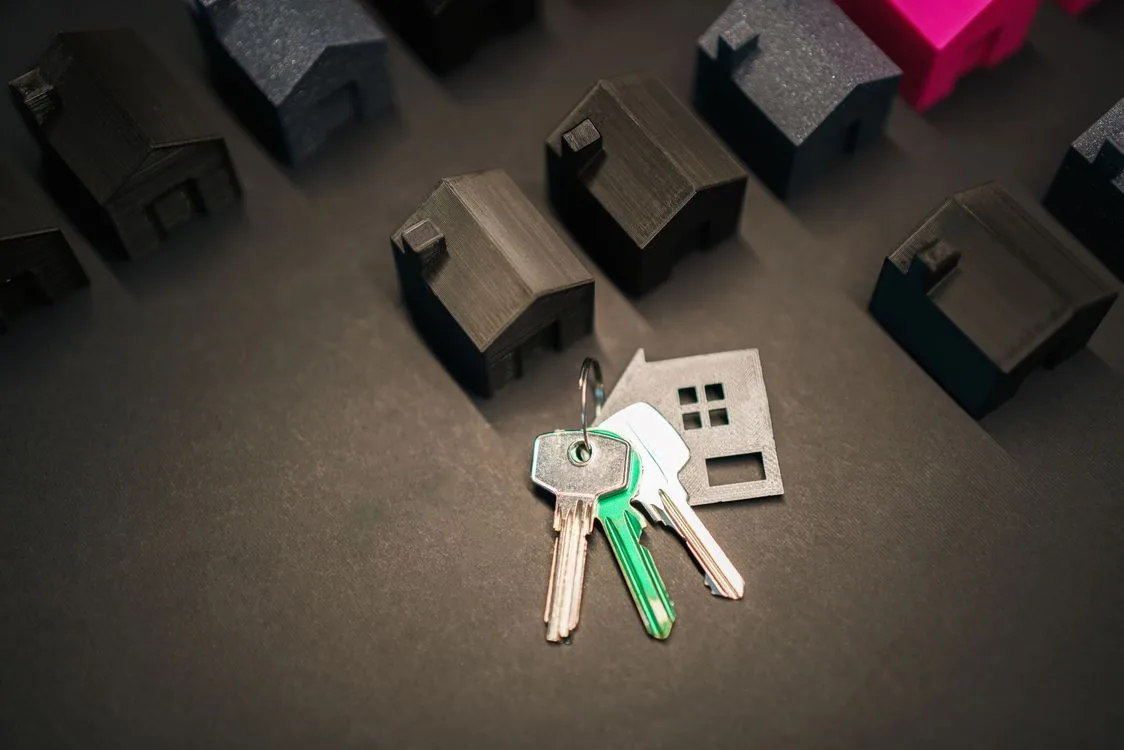 Concepto de bienes raíces con llaves y modelos de casas sobre una mesa
